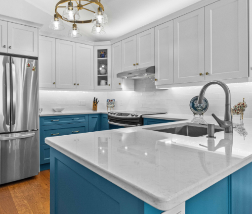 Kitchen with blue cupboards, stone countertops, and stainless steel fixtures